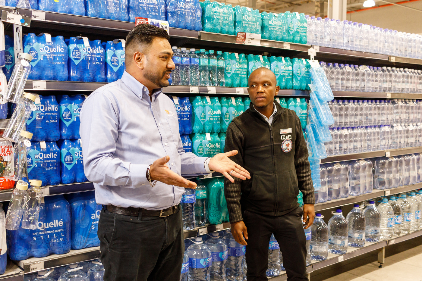 Meridian field representative discussing shelf execution with a store manager in the water aisle